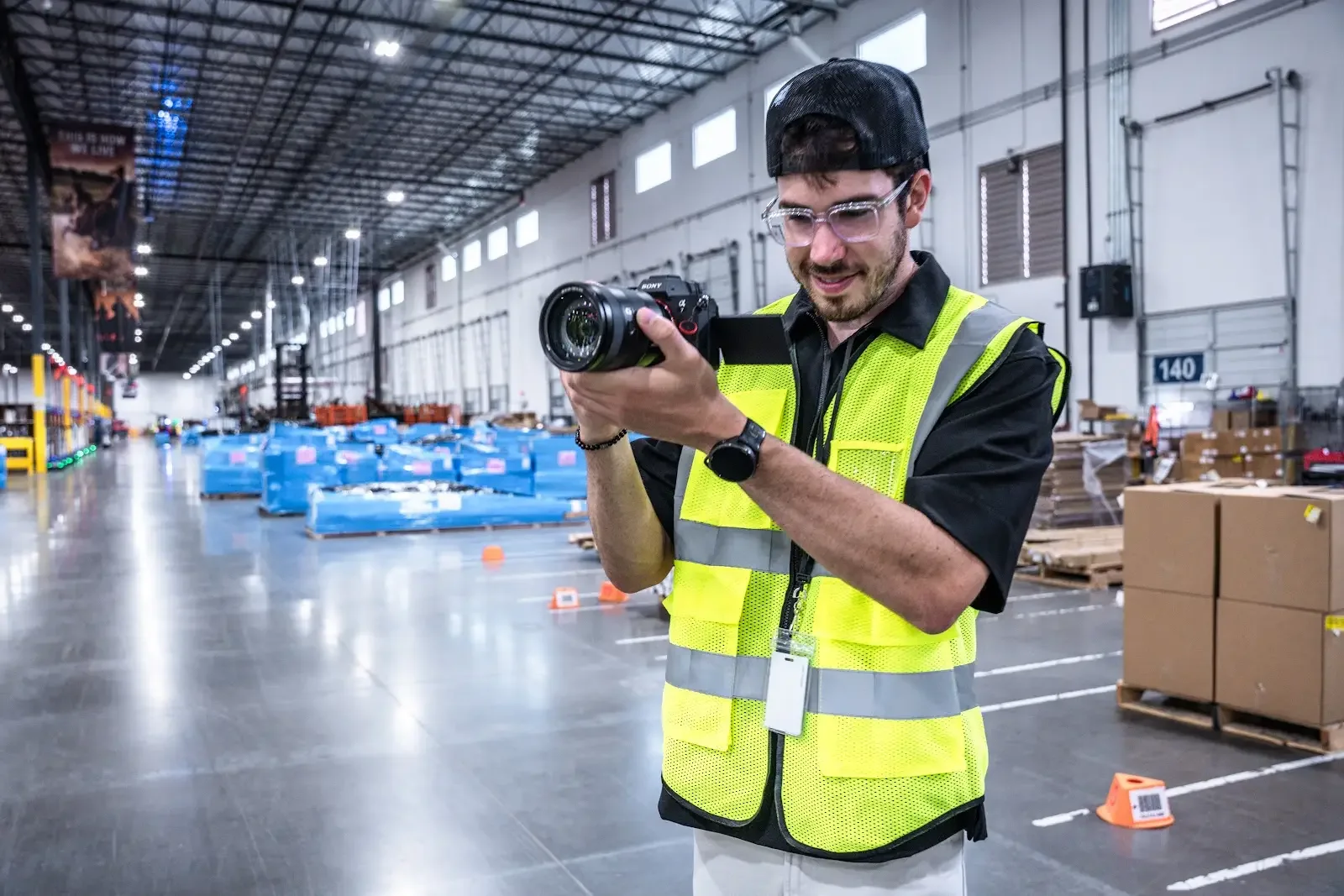 An EventShark camera operator checking a shot on the floor of a fulfillment warehouse