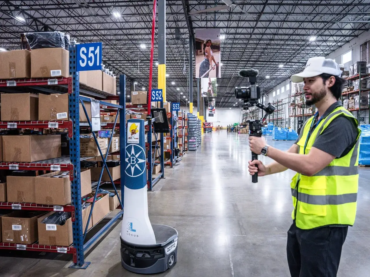 Ding Zheng filming a warehouse robot in a distribution center